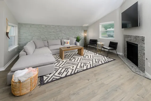 a living room with furniture fireplace and flat screen tv