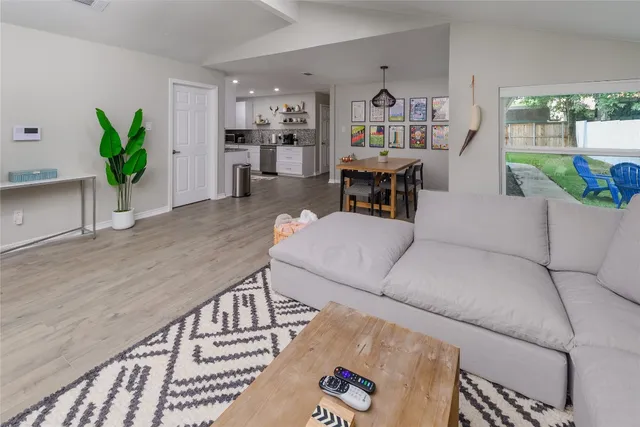 a living room with furniture and a wooden floor