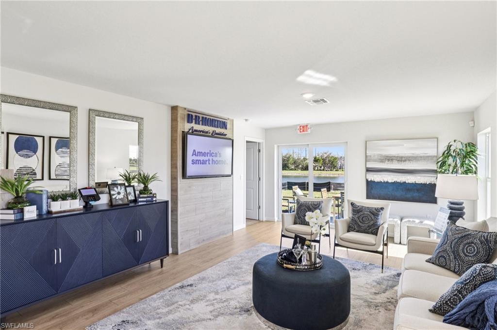 8040 Cedar Ky Way Lehigh Acres, FL 33971 - Photo 2 of 27 Model home. Living area with light wood finished floors and a water view