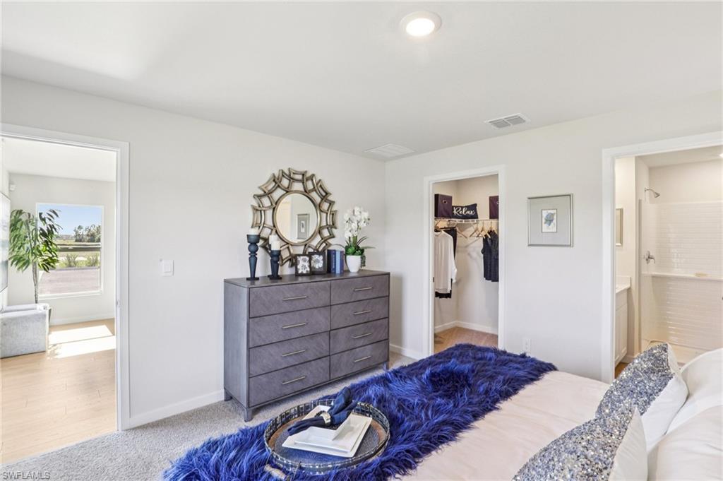 8040 Cedar Ky Way Lehigh Acres, FL 33971 - Photo 22 of 27 Model home. Bedroom featuring a spacious closet and light carpet