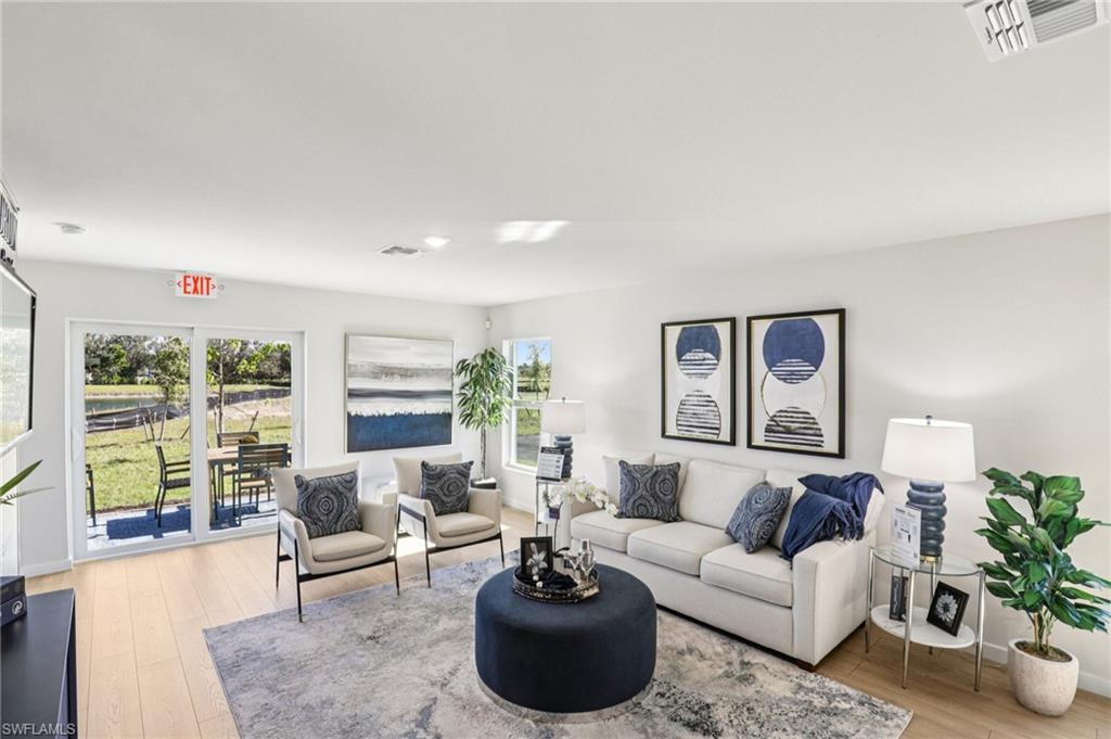 8040 Cedar Ky Way Lehigh Acres, FL 33971 - Photo 3 of 27 Model home. Living area featuring light wood-style floors and baseboards