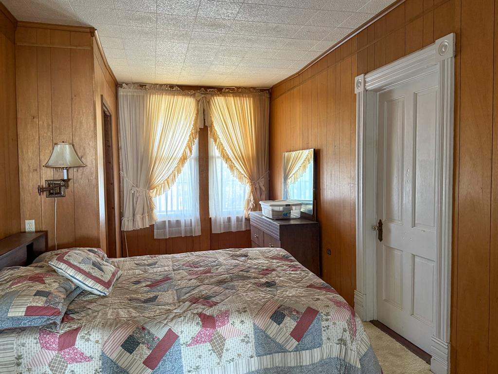 641 West 2nd Street Baird, TX 79504 - Photo 14 of 15 a bedroom with a bed and a large mirror next to a window
