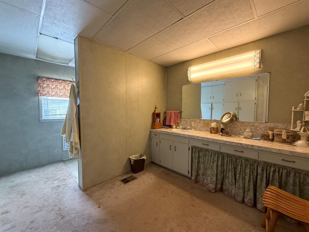 641 West 2nd Street Baird, TX 79504 - Photo 10 of 15 a spacious bathroom with a double vanity sink and a mirror
