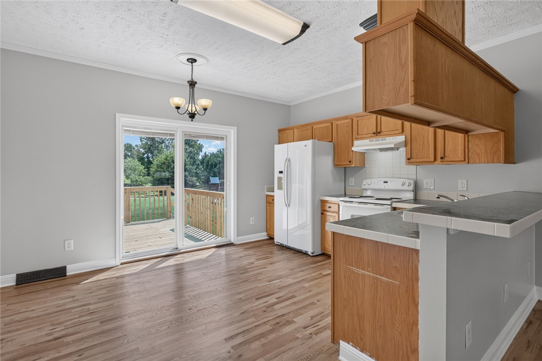 564 Fairfield Road Walhalla, SC 29691 - Photo 10 of 50 Warm wood floors and classic oak cabinetry define this functional kitchen and dining space.