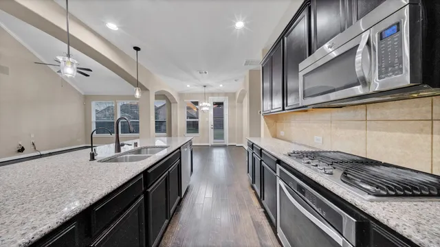 a kitchen with stainless steel appliances granite countertop a sink and stove