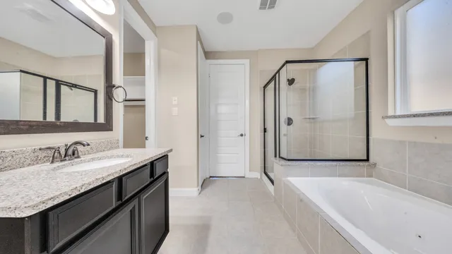 a spacious bathroom with a tub shower sink and mirror