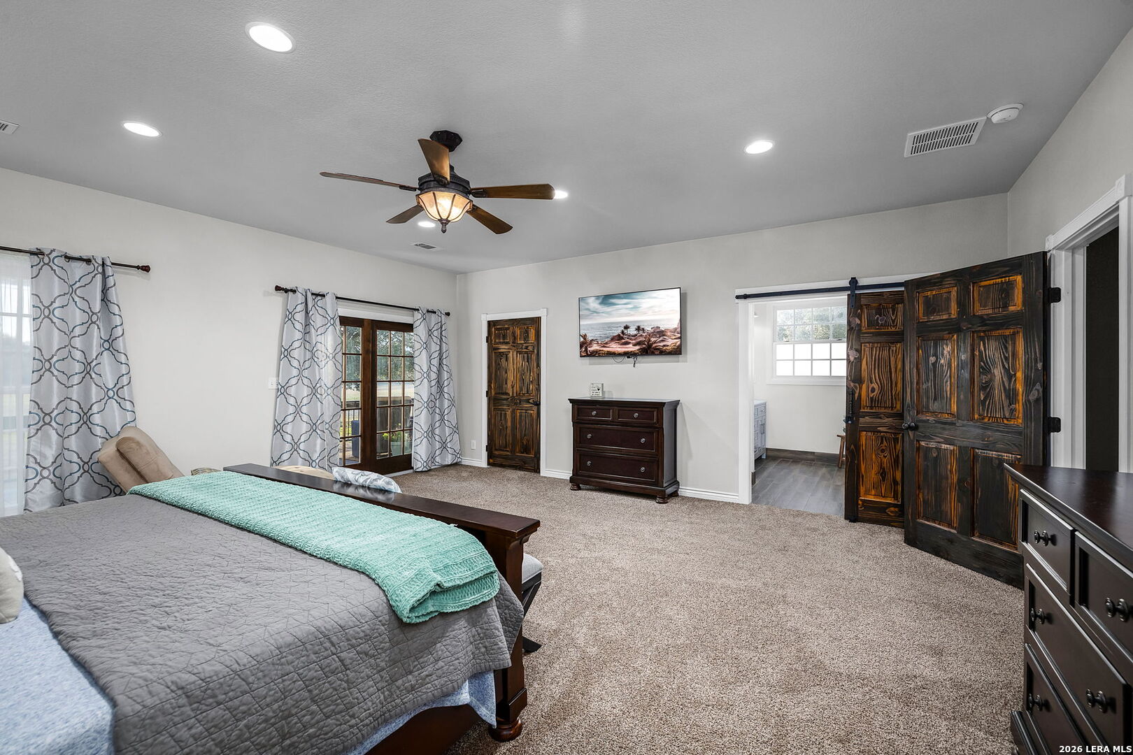 12700 Woman Hollering Road Schertz, TX 78154 - Photo 27 of 45 a bedroom with a bed and a chandelier
