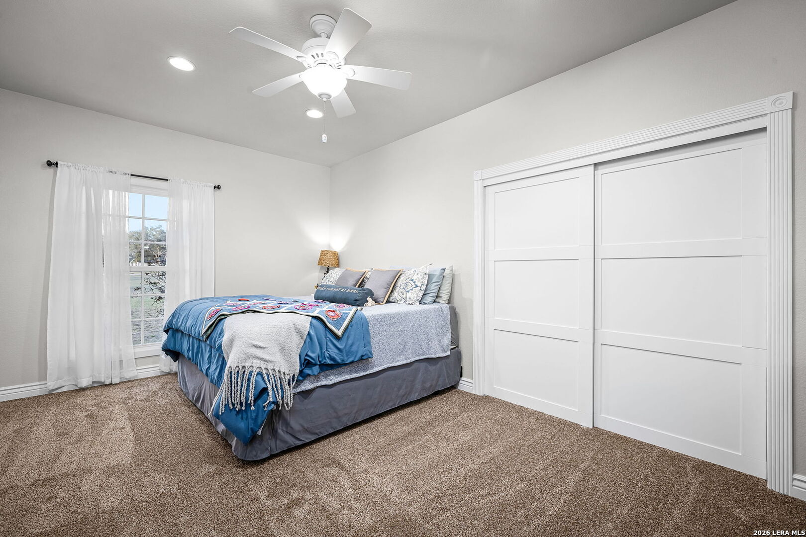 12700 Woman Hollering Road Schertz, TX 78154 - Photo 31 of 45 a spacious bedroom with a bed and a ceiling fan