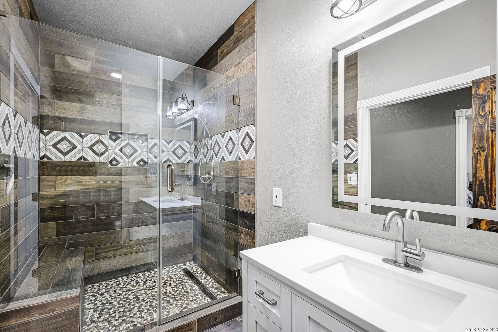 12700 Woman Hollering Road Schertz, TX 78154 - Photo 33 of 45 a bathroom with a sink shower and a mirror