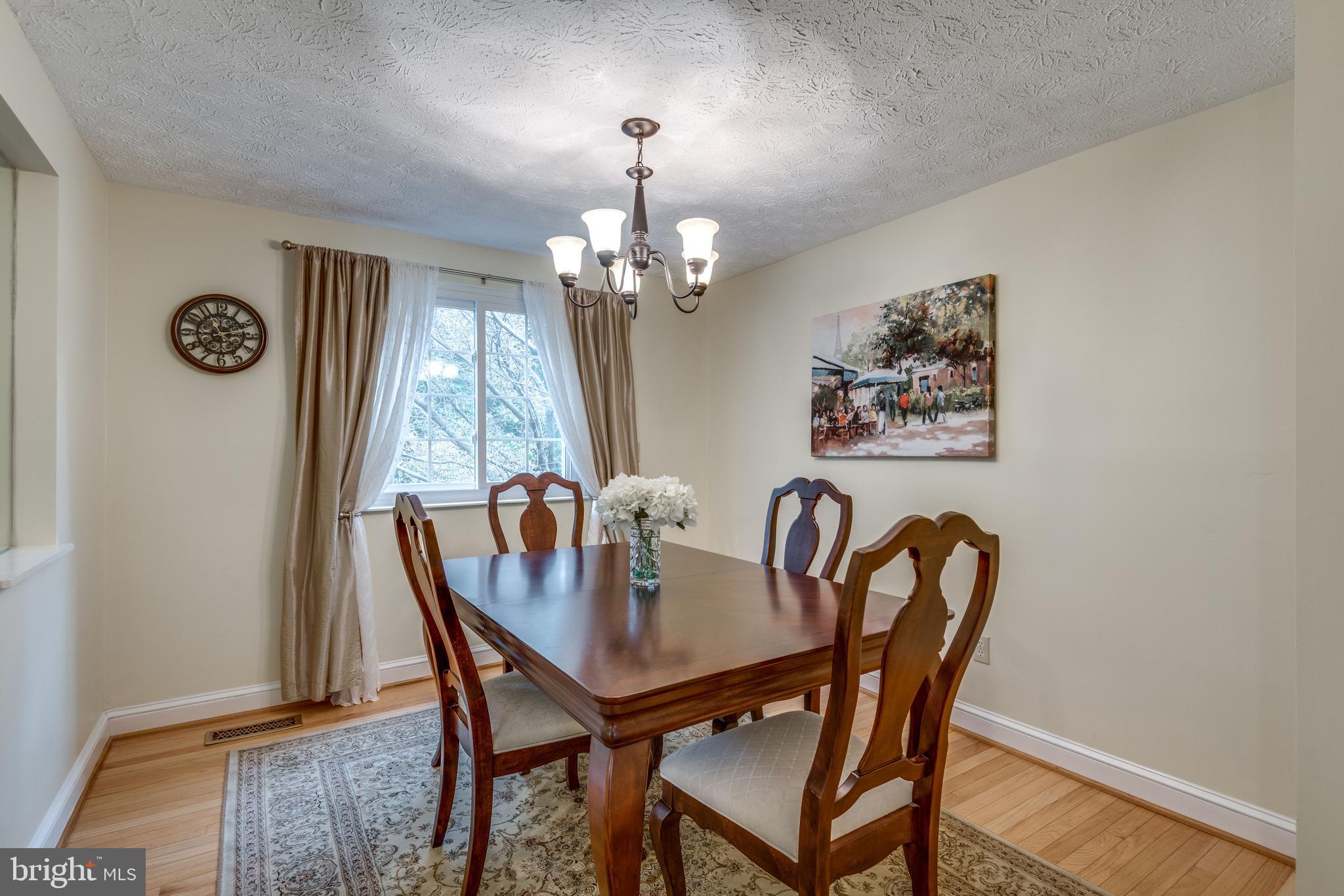 Dining room with picture window of wooded backyd