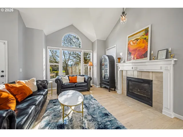 a living room with furniture a fireplace and a large window