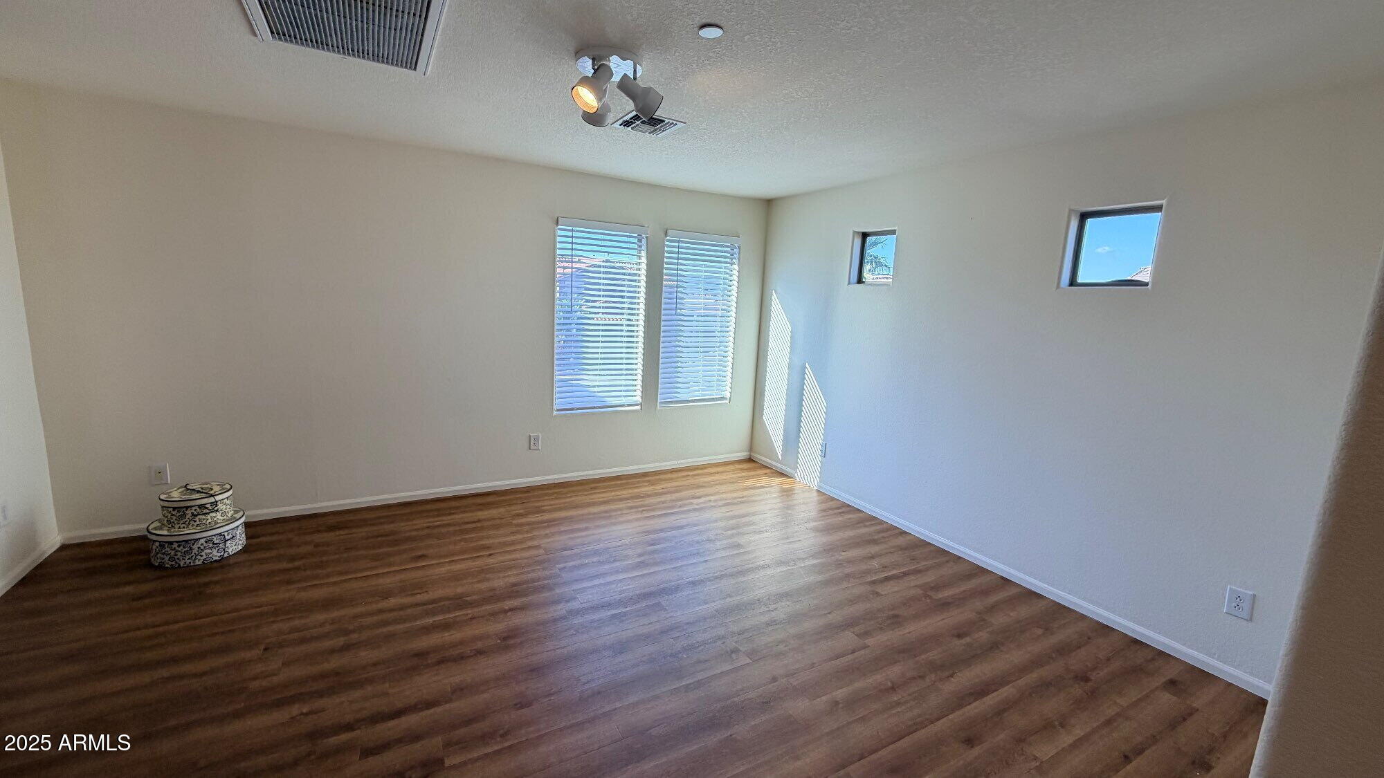 21549 Backus Drive Maricopa, AZ 85138 - Photo 20 of 28 a view of an empty room with wooden floor and a window