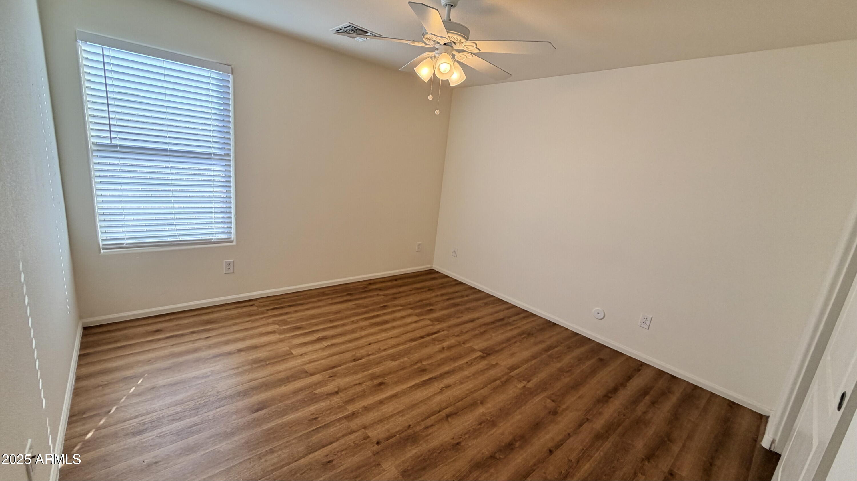 21549 Backus Drive Maricopa, AZ 85138 - Photo 25 of 28 an empty room with wooden floor fan and window