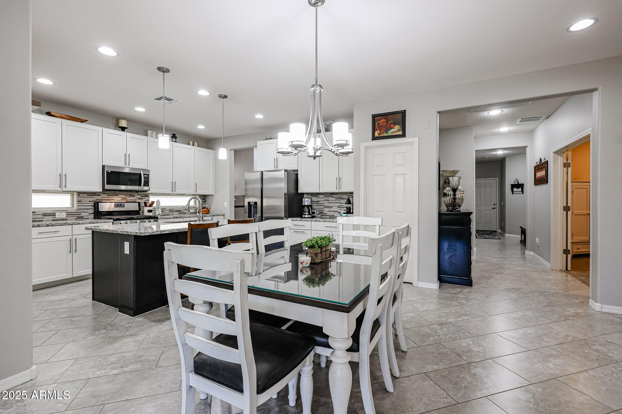 17563 West Fairview Street Goodyear, AZ 85338 - Photo 12 of 66 a kitchen with stainless steel appliances granite countertop a refrigerator a stove a sink a dining table and chairs