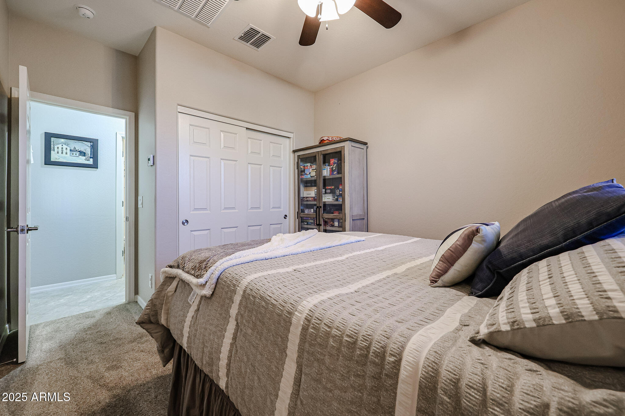 17563 West Fairview Street Goodyear, AZ 85338 - Photo 30 of 66 a bedroom with a bed and a chandelier