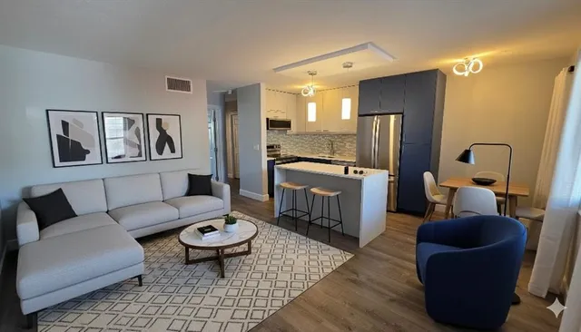 a living room with furniture and a view of kitchen