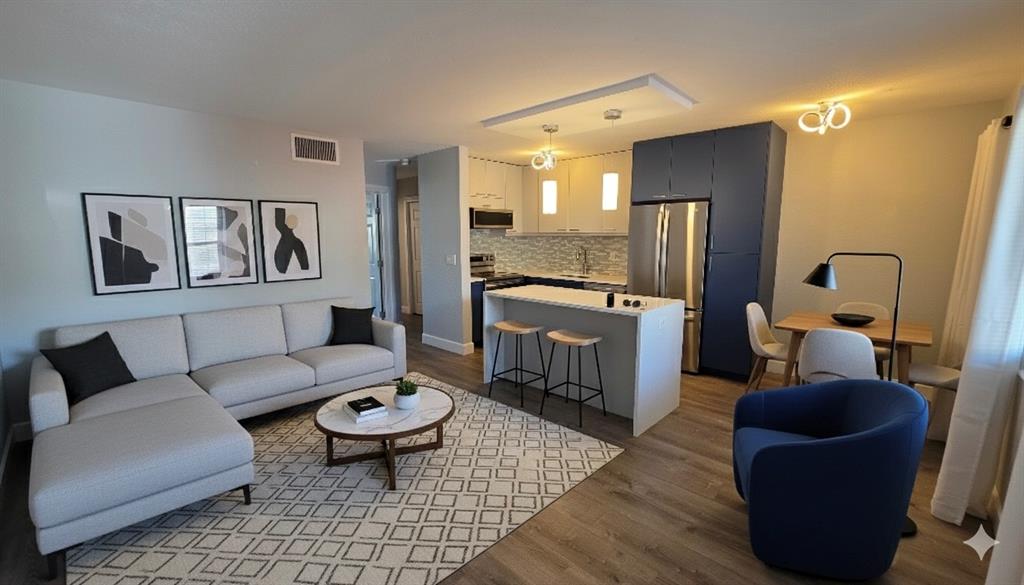 a living room with furniture and a view of kitchen