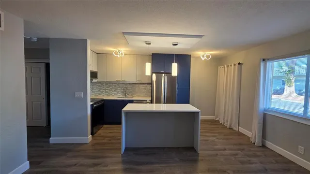 a view of kitchen with stainless steel appliances granite countertop cabinets and wooden floor