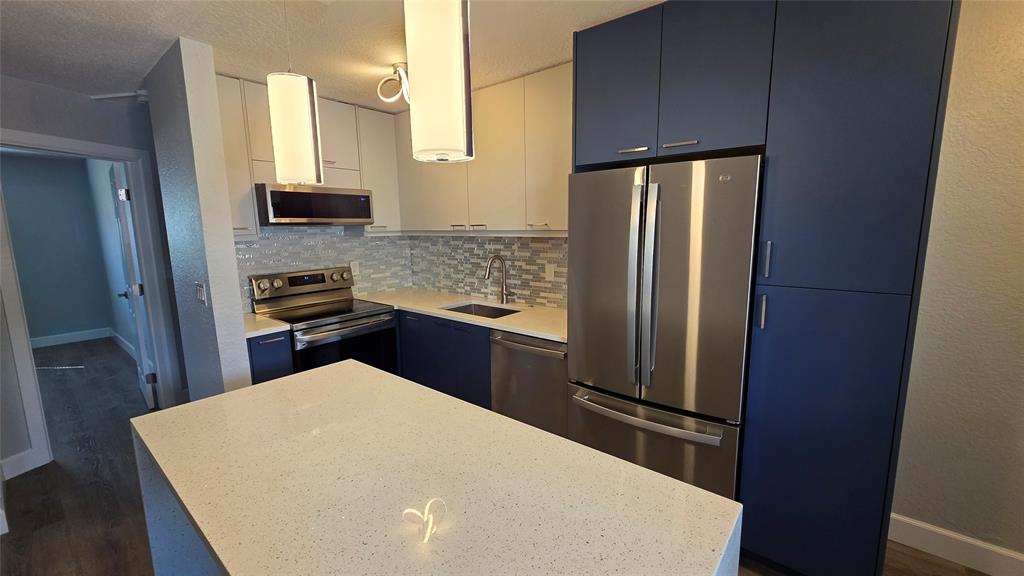 2607 Northeast 8th Avenue, Unit 14 Wilton Manors, FL 33334 - Photo 4 of 12 a kitchen with stainless steel appliances a refrigerator and wooden cabinets
