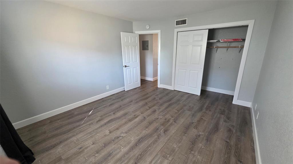 2607 Northeast 8th Avenue, Unit 14 Wilton Manors, FL 33334 - Photo 9 of 12 an empty room with wooden floor and closet