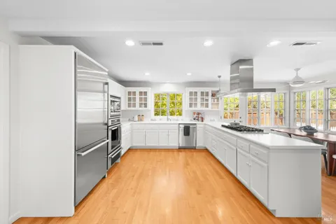 a large white kitchen with a large window