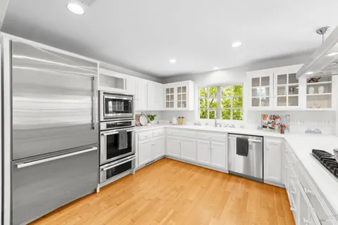 a kitchen with a sink stainless steel appliances and window