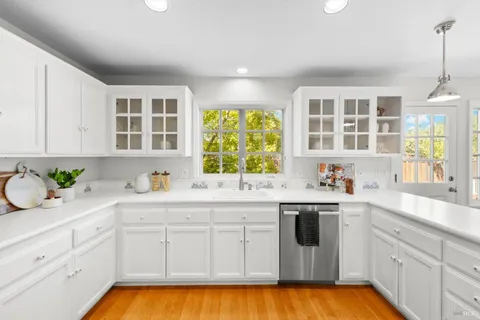 a kitchen with a sink window and cabinets