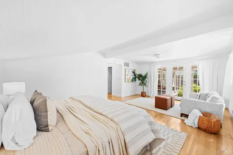 a bedroom with a bed and wooden floor
