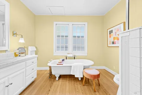 a bathroom with a sink a toilet a mirror and a tub