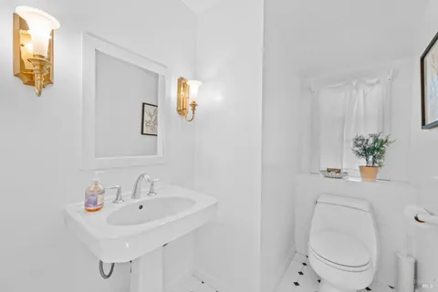 a bathroom with a sink a toilet and mirror