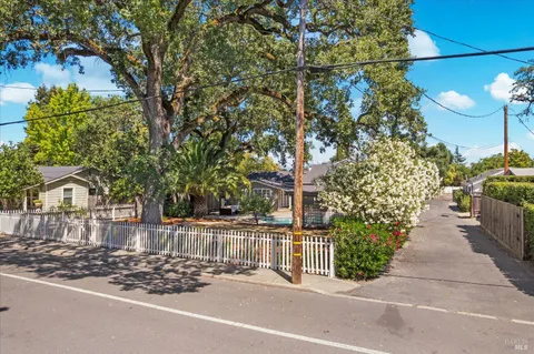 a view of a house with a tree and flower plants