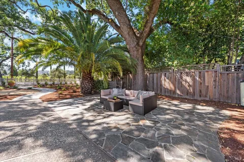 a view of a backyard with table and chairs and wooden fence