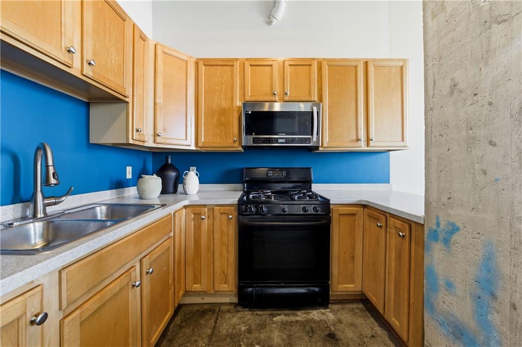 505 Whitehall Street Southwest, Unit 203 Atlanta, GA 30303 - Photo 11 of 36 a kitchen with stainless steel appliances granite countertop a stove a sink and a microwave