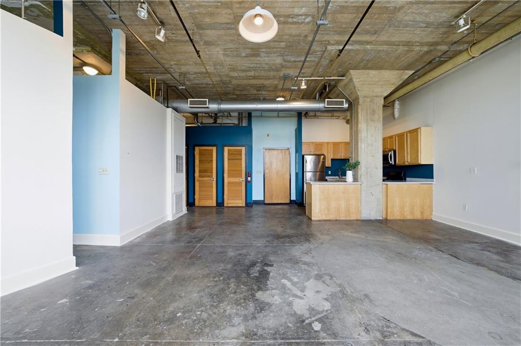505 Whitehall Street Southwest, Unit 203 Atlanta, GA 30303 - Photo 8 of 36 a view of a hallway with wooden cabinet and refrigerator