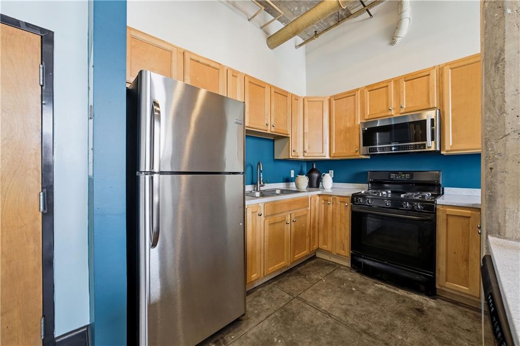505 Whitehall Street Southwest, Unit 203 Atlanta, GA 30303 - Photo 10 of 36 a kitchen with stainless steel appliances granite countertop a refrigerator stove and microwave