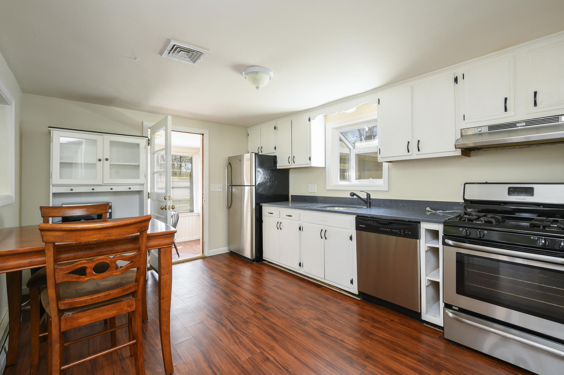 17 Farm Hill Road Centerville, MA 02632 - Photo 9 of 25 a kitchen with stainless steel appliances granite countertop a stove top oven a sink dishwasher and a refrigerator with wooden floor