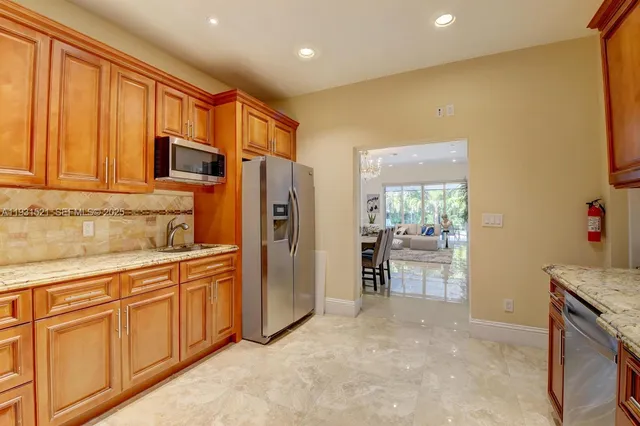 a kitchen with stainless steel appliances granite countertop a refrigerator and cabinets