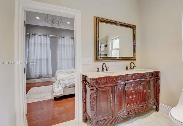 a en suite bathroom with a granite countertop sink and a mirror