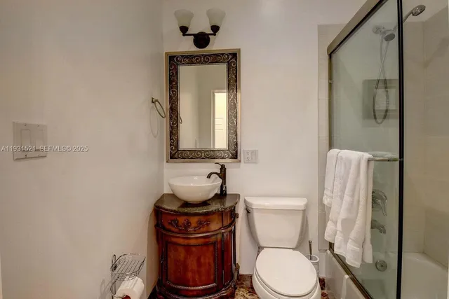 a white toilet sitting next to a bathroom sink
