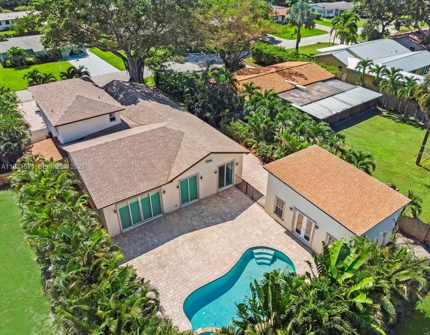 an aerial view of a house with swimming pool and garden view
