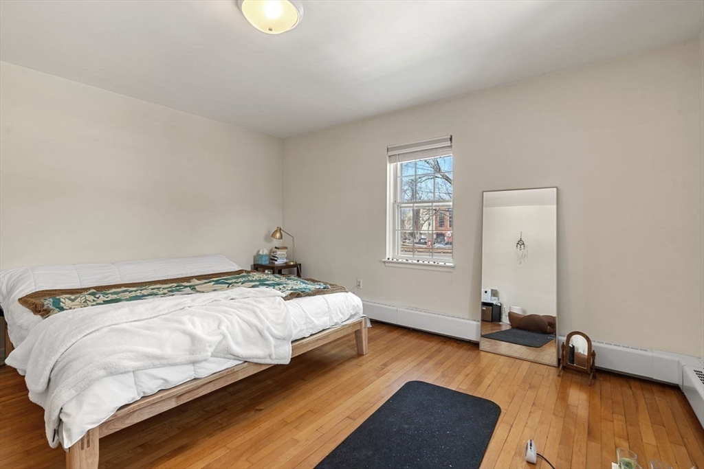 76 Boylston Street, Unit 4 Newton, MA 02467 - Photo 6 of 14 a bedroom with a bed and wooden floor