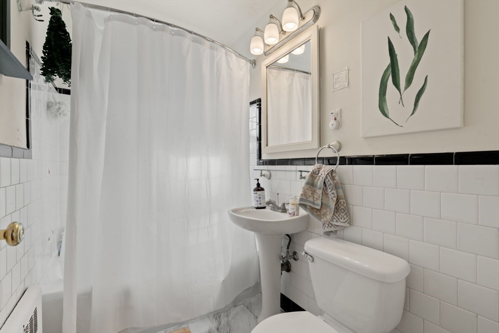 76 Boylston Street, Unit 4 Newton, MA 02467 - Photo 9 of 14 a bathroom with a toilet sink and mirror
