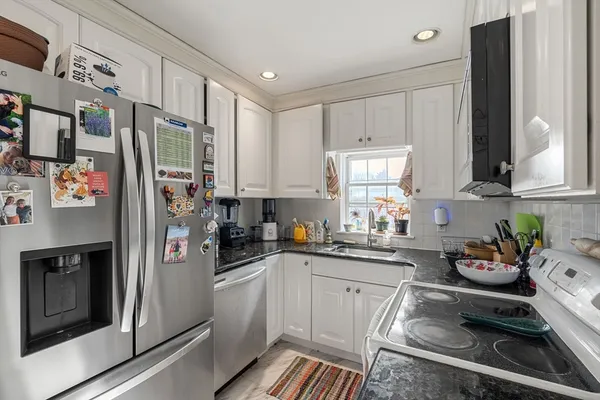 a kitchen with stainless steel appliances a refrigerator sink and cabinets