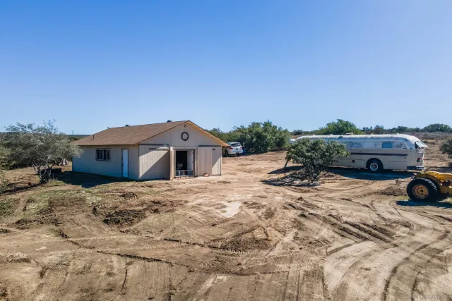 an aerial view of a house with a yard and wooden fence