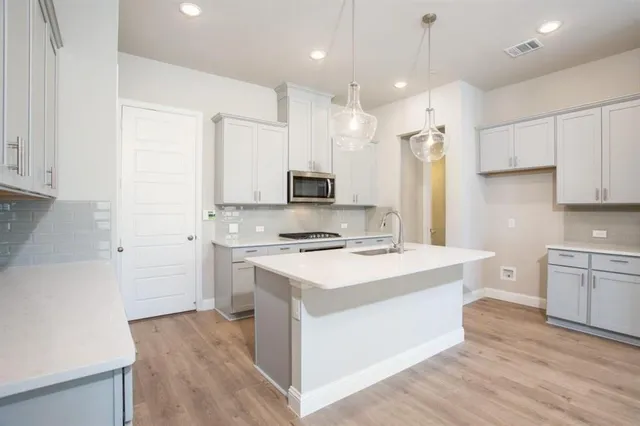 a kitchen with a stove a sink and a refrigerator