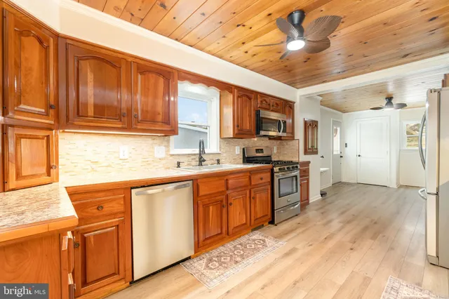 a kitchen with stainless steel appliances granite countertop a refrigerator a stove top oven a sink and dishwasher