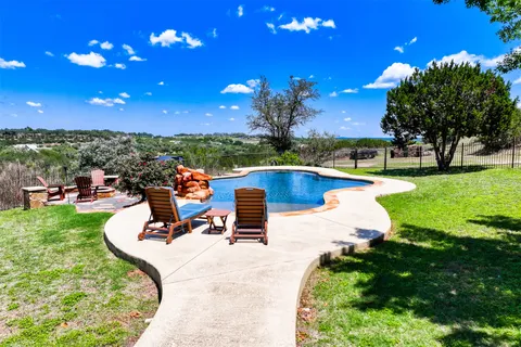 a swimming pool with outdoor seating and a garden