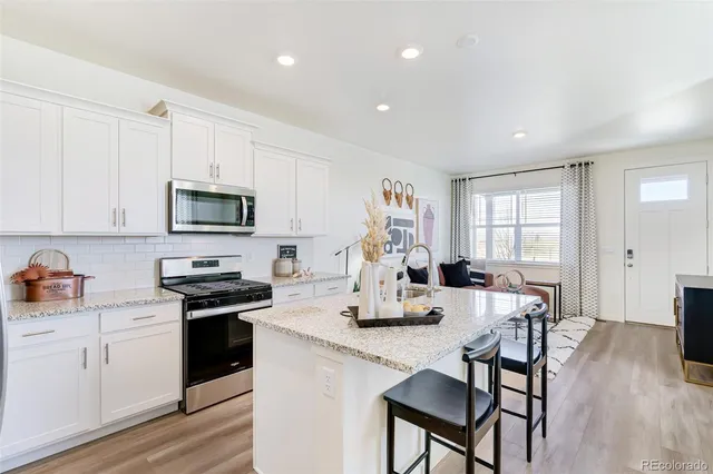 a kitchen with sink a microwave and cabinets