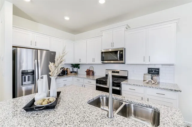 a kitchen with stainless steel appliances kitchen island granite countertop a refrigerator sink and stove