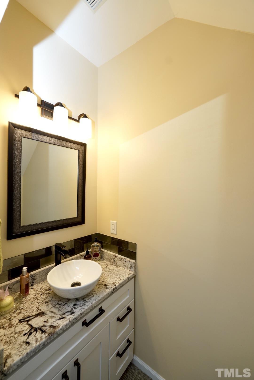 8335 City Loft Court Raleigh, NC 27613 - Photo 11 of 18 a bathroom with a granite countertop sink and a mirror